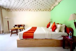 1 dormitorio con 1 cama grande con almohadas de color rojo y naranja en Sultan Bagh Resort by The Sky Imperial, en Sawāi Mādhopur