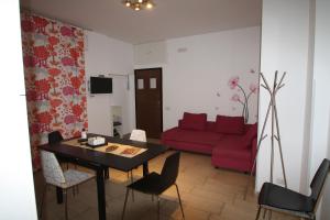 ein Wohnzimmer mit einem Tisch und einem roten Sofa in der Unterkunft Appartamenti Giusy e Giusy 2 in Sorrent