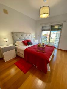 um quarto com uma cama grande e um cobertor vermelho em Concordia Apartment no Funchal