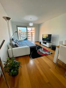 a living room with a white couch and a television at Concordia Apartment in Funchal