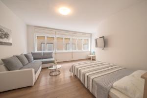 salon z kanapą i łóżkiem w obiekcie Aurora Apartment Zadar w mieście Zadar