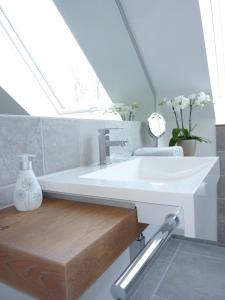 ein Bad mit einem weißen Waschbecken und einem Fenster in der Unterkunft Ferienwohnung am Wald - a10692 in Goslar