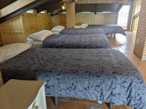 a group of four beds in a room at Villa El Rosal del Pozo, a 5 minutos de Puy du Fou in Layos