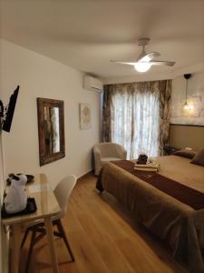 a bedroom with a bed and a table and a window at Hostal Casa Mercedes in Nerja