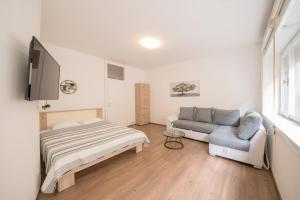 a bedroom with a bed and a couch and a tv at Central View Zadar in Zadar