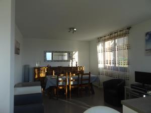uma sala de jantar com uma mesa e cadeiras e uma janela em Au pied du Pertuiset em Drumettaz-Clarafond