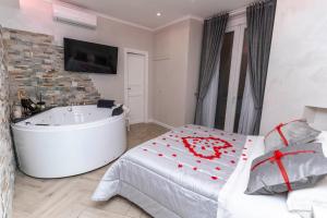 a bedroom with a tub and a bed and a television at Silver Suite Coliseum in Rome