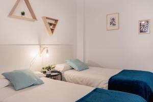 2 camas en una habitación con paredes blancas en Apartamentos FV Flats Valencia - Mestalla 9, en Valencia