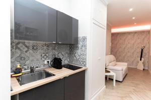 a kitchen with a sink and a living room at Silver Suite Coliseum in Rome