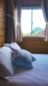 a bed with pillows and a window in a bedroom at Bangalôs Floripa - Tiny House in Florianópolis