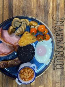 a blue plate of food with eggs bacon mushrooms and beans at Imaginarium restaurant in Barton upon Humber