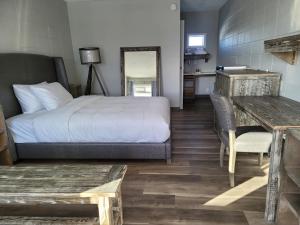 1 dormitorio con cama, mesa y escritorio en Parkside Inn en Grande Prairie