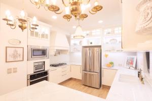 a kitchen with white cabinets and a stainless steel refrigerator at Hotel Casamada in San Miguel de Allende