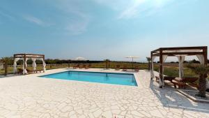 a swimming pool with two chairs and a gazebo at Villa Melody Novalja in Novalja