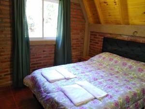 a bedroom with a bed with towels on it at Alpinas Sol y Luna VGB in Villa General Belgrano
