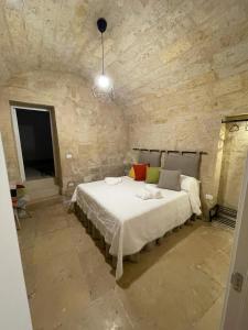 a bedroom with a large bed in a stone wall at L’INFANZIA HOLIDAY HOME in Bari