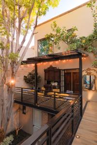 a house with a deck with a grill and a tree at Hotel Casamada in San Miguel de Allende