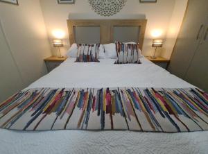 a bed with a colorful blanket on top of it at Casa Oliphaunt in Kent