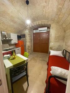 a small kitchen with a bed and a table in a room at L’INFANZIA HOLIDAY HOME in Bari