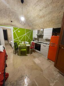 a kitchen with a table and a green wall at L’INFANZIA HOLIDAY HOME in Bari