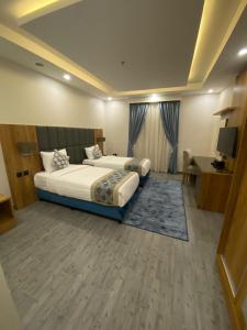 a hotel room with two beds and a television at PRIMOTEL Elite As Salamah in Jeddah