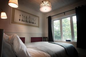 a bedroom with a bed and a window at Manoir du Lac Sept-Îles in Saint-Raymond