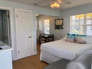 um quarto com uma cama branca e um sofá em Sabal Palms Inn em St Pete Beach