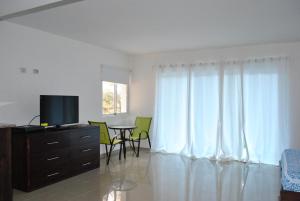 sala de estar con TV y mesa con sillas en Vue Apartment Hotel en Cabo Haitiano