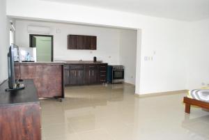 a large kitchen with wooden cabinets and a stove at Vue Apartment Hotel in Cap-Haïtien