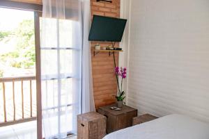 a bedroom with a bed and a window with a television at Casa Boutique in Cunha