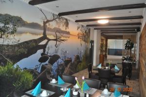 Parkhotel Schwedt في شفيدت: غرفة طعام بها لوحة كبيرة على البحيرة