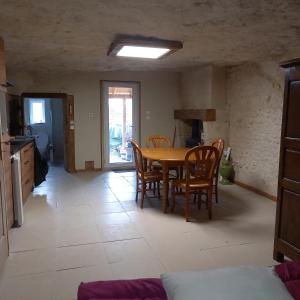 een keuken en eetkamer met een tafel en stoelen bij gite-civray-de-touraine TROGLO de Denise in Civray-de-Touraine