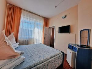 a hotel room with a bed and a television at Hotel Belvedere in Piatra Neamţ