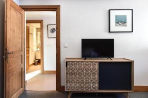 uma sala de estar com uma televisão de ecrã plano num armário em Appartement Le Caboen Les Planards em Chamonix-Mont-Blanc