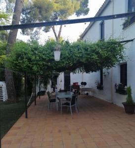 un patio con mesa y sillas bajo una pérgola en PUERTA DEL SOL, en Almansa