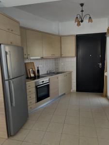 a kitchen with stainless steel appliances and a black door at Christos in Rafina