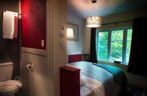 a small bedroom with a bed and a window at Manoir du Lac Sept-Îles in Saint-Raymond