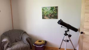 uma câmara num tripé ao lado de uma cadeira e de um quadro em Bienvenido a Campo Alerce em Teno