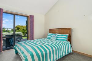 Een bed of bedden in een kamer bij Edgewater Escape - Cromwell Holiday Home