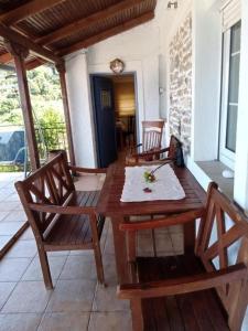 a wooden table and chairs on a patio at La Casa del Sol in Keramídhion