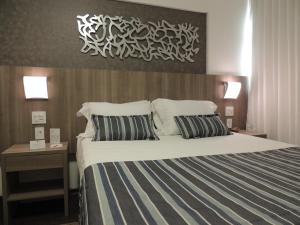 Cama ou camas em um quarto em Allia Gran Pampulha Suites