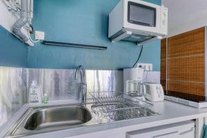 a kitchen with a sink and a microwave at Charmant studio à 5 minutes de la mer à pied in Saint-Nazaire