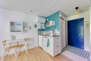 a small kitchen with a table and a blue wall at Charmant studio à 5 minutes de la mer à pied in Saint-Nazaire