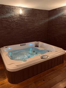 uma banheira de hidromassagem com luzes azuis num quarto em Mieuxqualhotel jacuzzi privatif Le carré em Bordeaux