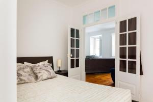 リスボンにあるEstrela Garden Apartmentの白いベッドルーム(ベッド1台付)とベッドルーム