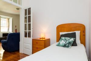 里斯本的住宿－Estrela Garden Apartment，一间卧室配有一张床和一张蓝色椅子