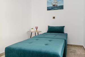 a bedroom with a blue bed and a table at Golden Rose Elegant Vacation Home in Naxos Chora