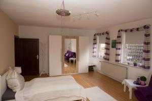een slaapkamer met een wit bed en een woonkamer bij Ferienwohnung Falk in WÃ¶lpinghausen