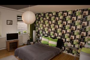 a bedroom with a bed and a wall with a wallpaper at Ferienwohnung Falk in WÃ¶lpinghausen