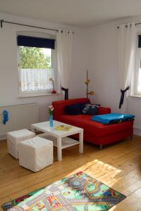 een woonkamer met een rode bank en een tafel bij Ferienwohnung Falk in WÃ¶lpinghausen